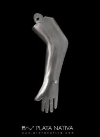 Ex voto de plata, en forma de brazo extendido, realizado en lámina repujada con orificion superior para colgar. Reperesenta una ofrenda devocional vinculada a la curación o protección del miembro representado.